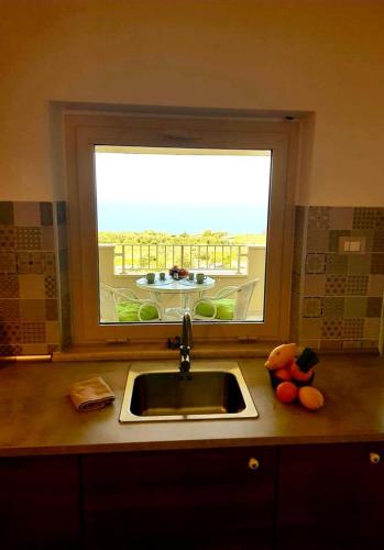 a kitchen counter with a sink and a window at Casa Vacanza Mata in Zambrone