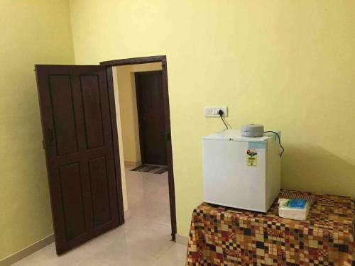 a room with a refrigerator next to a door at Viva la Veda in Karunāgapalli