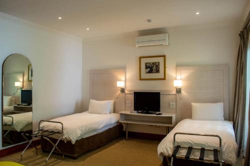 a hotel room with two beds and a television at Val Du Charron Wine & Leisure Estate in Wellington