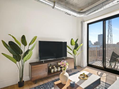 a living room with a flat screen tv on a wall at Clover Luxury High-Rise DownTown South Bend in South Bend