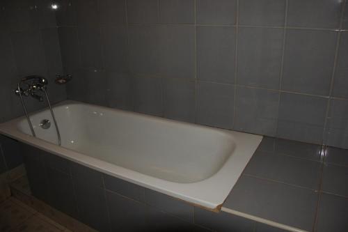 a bath tub with a faucet in a bathroom at Motel Tuku Masindi in Masindi