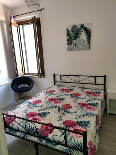 a bedroom with a bed with a floral comforter at Casa vacanza il Campanile in Alghero