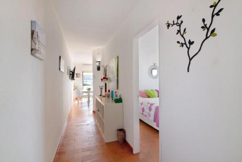 a white hallway with a bedroom and a bed at Ouramar Apartment in Areias de São João