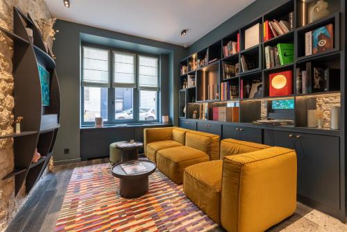 a living room with a couch and a tv at Hôtel Amoi Paris in Paris
