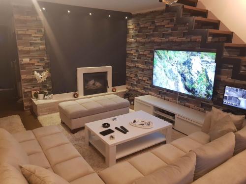 a living room with a couch and a tv at Sarajevo Sky View in Sarajevo