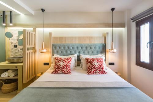 a bedroom with a bed with red and white pillows at C Suites in Rethymno Town