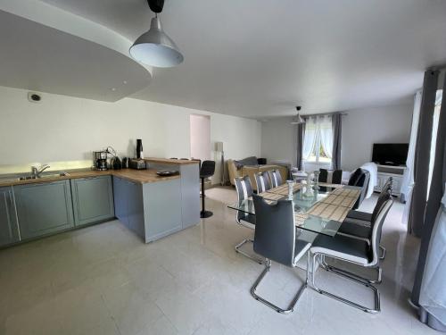 a kitchen and living room with a table and chairs at LA MAISON DE DELSY in Binson-et-Orquigny