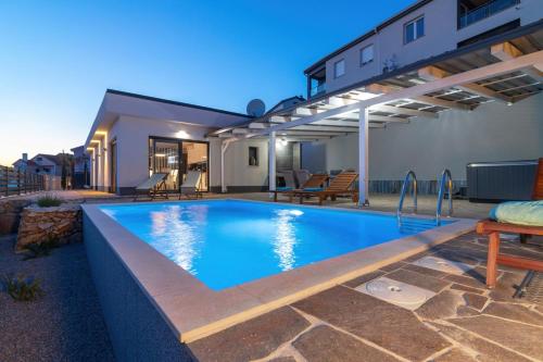 a swimming pool in the backyard of a house at Villa Belissima Vista Mare in Selce