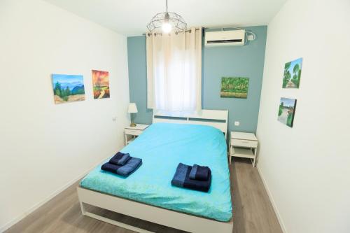 a bedroom with a blue bed with two pillows at Mandy's Place - By Soroka Medical Center and BGU in Beer Sheva