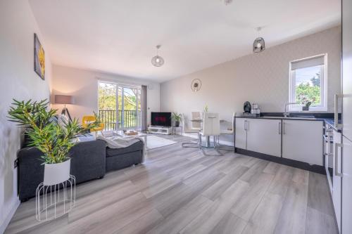 Cet appartement comprend un salon avec un canapé et une cuisine. dans l'établissement Ash View Place 4 -Heathrow - Thorpe Park - Free Parking, à Staines