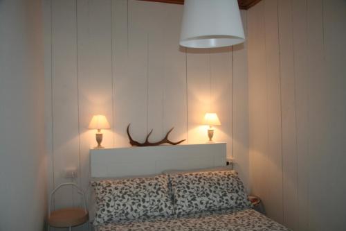 a bedroom with a bed with two lamps on the wall at nel cuore di Bormio in Bormio