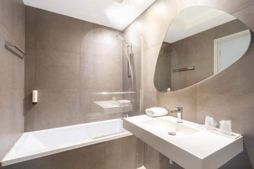 a bathroom with a sink and a mirror at Hôtel Vauban Briançon Serre Chevalier in Briançon