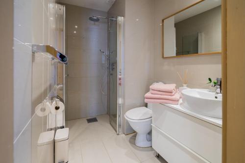 ein Bad mit einer Dusche, einem WC und einem Waschbecken in der Unterkunft Cozy apartment in Alesund city in Ålesund