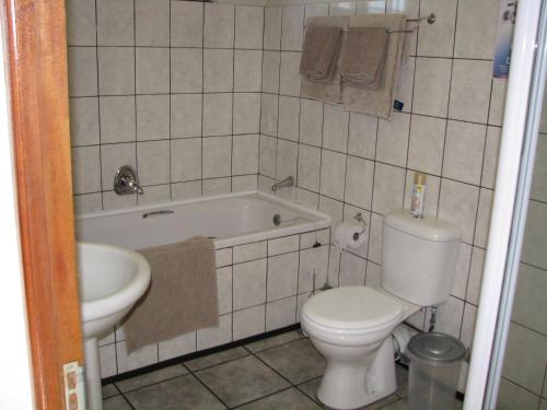een badkamer met een toilet, een bad en een wastafel bij Kaiser's B&B in Grahamstown