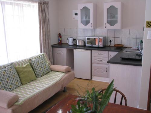 a living room with a couch and a kitchen at Kaiser's B&B in Grahamstown