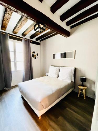 um quarto com uma cama branca e uma janela em Cosy Home Muret em Chartres