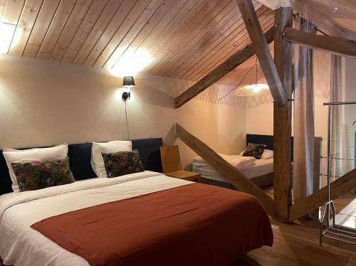 a bedroom with two beds in a room with wooden ceilings at Le Clos de Miribel in Givry