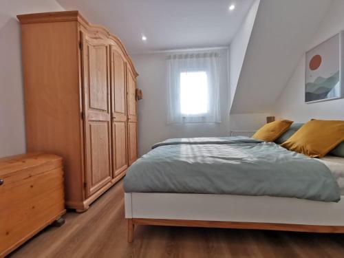 ein Schlafzimmer mit einem großen Bett und einem Holzschrank in der Unterkunft Ferienwohnung Koblenz Goldgrube in Koblenz
