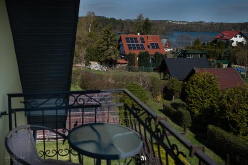 a balcony with a table and a view of the water at Kaszubski Dworek in Sznurki