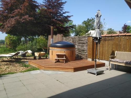 eine Holzterrasse mit einem Pavillon im Hof in der Unterkunft Chalet "Het Biggetje" met hottub in Volkel