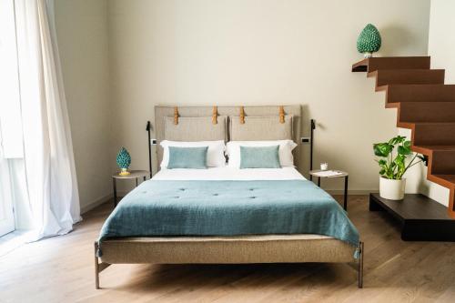 a bedroom with a bed with blue sheets and a staircase at InCanto in Palermo