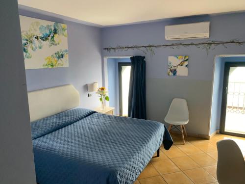 a bedroom with a blue bed and a window at Luna Convento Copanello B&B in Stalettì