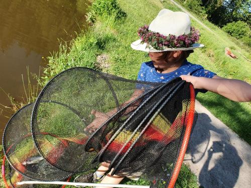 a woman in a hat holding a net at Riversight in Les Deux-Acren