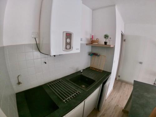 een kleine keuken met een groen aanrechtblad en een spoelbak bij Studio 4 couchages Port Du Cap d'Agde in Cap d'Agde