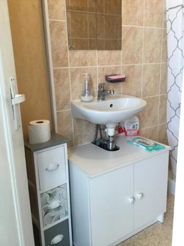 une salle de bain avec un lavabo blanc et un meuble dans l'établissement Avec un minimum de 3 nuits Studio 80 m de la mer et 300 m des commerces, au Tréport