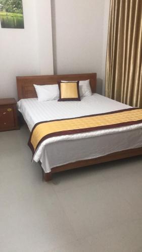a bedroom with a bed with a wooden headboard at Nha nghi PAC NGOI in Bak Kan