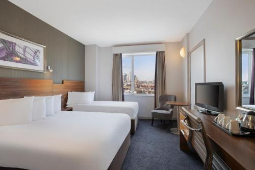 a hotel room with two beds and a television at Jurys Inn Leeds in Leeds