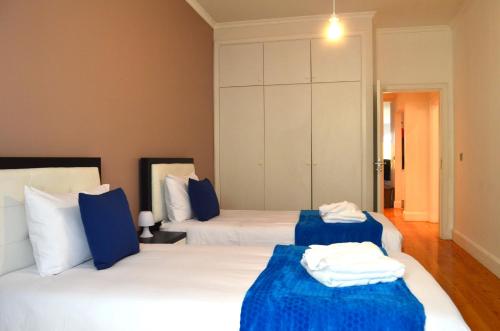a bedroom with two beds with blue and white sheets at ғᴜɴᴄʜᴀʟ ᴄᴇɴᴛᴇʀ- ᴅᴏᴡɴᴛᴏᴡɴ in Funchal