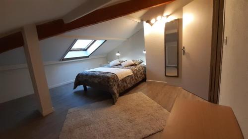 une chambre mansardée avec un lit et une fenêtre dans l'établissement Résidence Les Marines de Moriani pieds dans l'eau duplex avec terrasses vue mer, 4-8 pers, à San-Nicolao