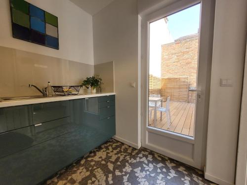 cocina con fregadero y puerta corredera de cristal en La maison de toujours, en La Garenne-Colombes