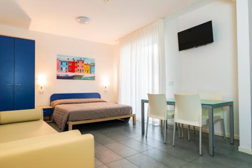ein Schlafzimmer mit einem Bett und einem Tisch und Stühlen in der Unterkunft Residence Burano in Lido di Jesolo