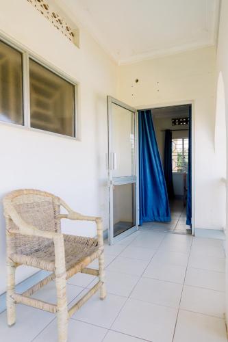 a rattan chair sitting in a room with a hallway at Acacia Villa Kampala in Kampala