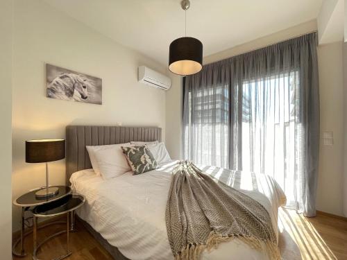 a bedroom with a bed and a large window at Athenean Modern Escape near Marina Flisvos in Athens