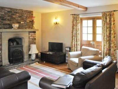 a living room with a couch and a fireplace at Beck House Cottages in Pickering