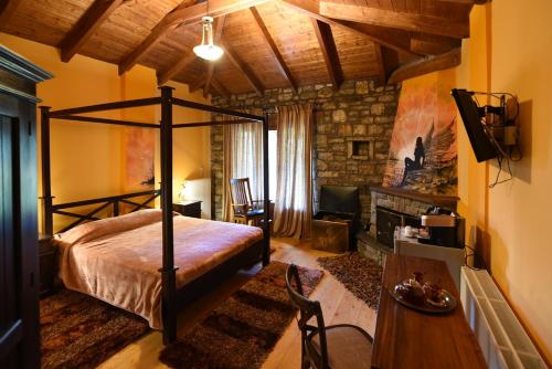 a bedroom with a canopy bed and a fireplace at Ta Petrina in Ano Chora