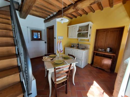 eine Küche und ein Esszimmer mit einem Tisch und Stühlen in der Unterkunft BELLA TUSCANY - Residence in Cireglio