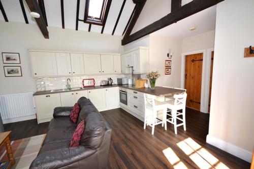 a living room with a couch and a kitchen at Beck House Cottages in Pickering