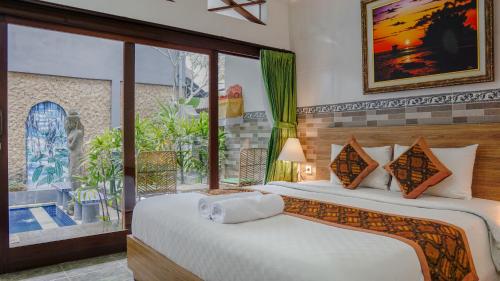 um quarto com 2 camas e uma grande janela em Pondok Pekak Guesthouse em Ubud