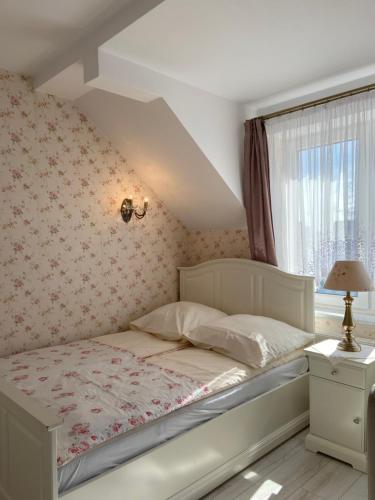 a bedroom with a bed and a window at Willa Pan Tadeusz in Łeba