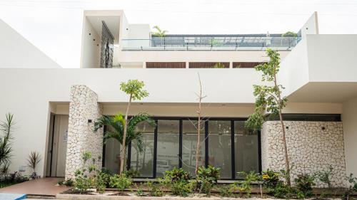 an external view of a house with plants at Moonshine Tulum Hotel & Hostel in Tulum