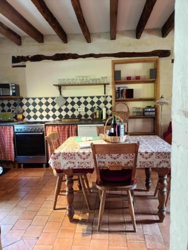 une cuisine avec une table et des chaises dans une pièce dans l'établissement Le Logis du Pressoir Self Catering Gites in beautiful 18th Century Estate in the heart of the Loire Valley with heated pool and extensive grounds., à Brion