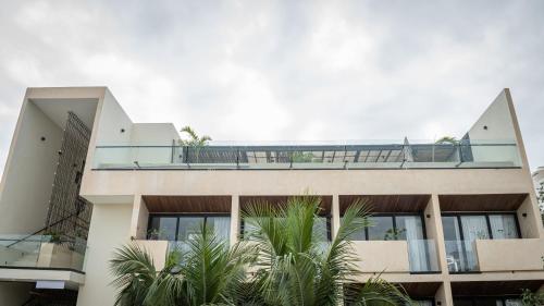 a building with palm trees in front of it at Moonshine Tulum Hotel & Hostel in Tulum