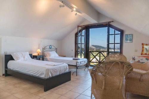 a bedroom with two beds and a large window at Villa Mitsa with stunning view on the Argassi hill in Argasi