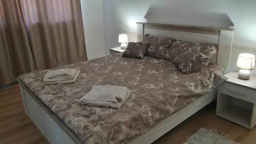a bedroom with a bed with two towels on it at Apartman river side in Soko Banja