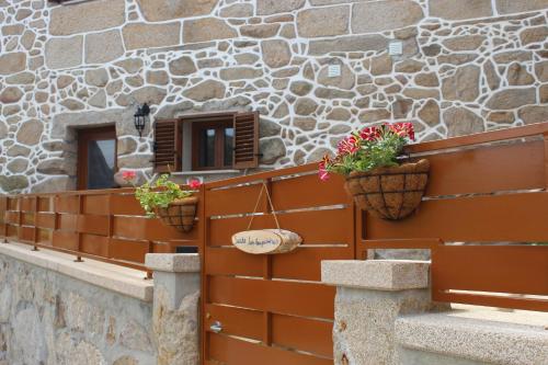 two potted plants on a fence next to a building at Suite das Fraguinhas in Sistelo