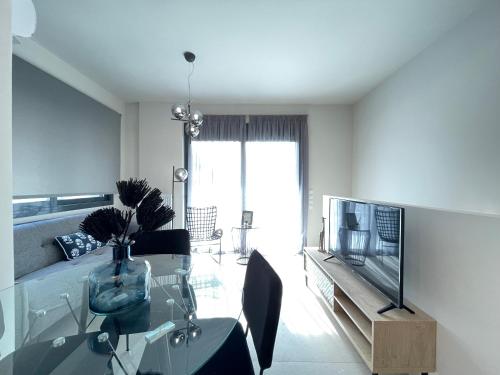a living room with a glass table and a television at Athenean Modern Escape near Marina Flisvos in Athens